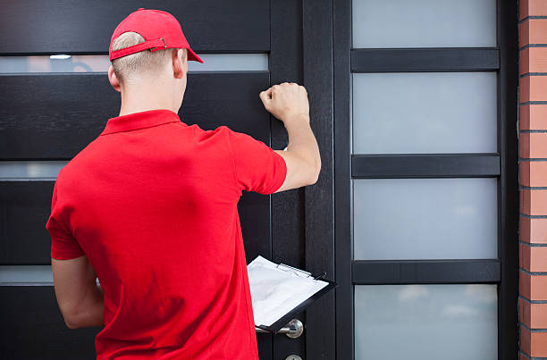 Delivery man knocking on the client's door Back view of a delivery man knocking on the client's door knocking on door stock pictures, royalty-free photos & images