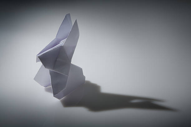 Black origami paper rabbit on white background.