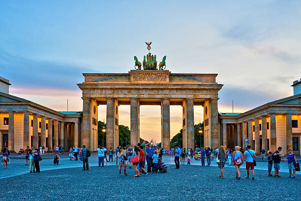 Brandenburg gate illuminated at sunset , Berlin, Germany Berlin, Germany - August 6, 2014: Tourists admiring the Brandenburg gate illuminated at sunset. brandenburg gate photos stock pictures, royalty-free photos & images