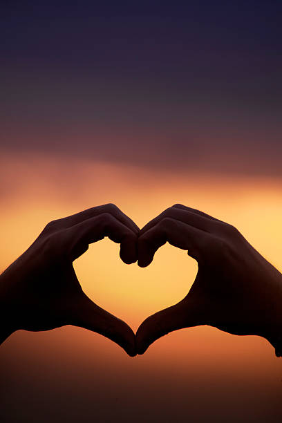 istock Hands in heart shape with dark sunset background. 509295294