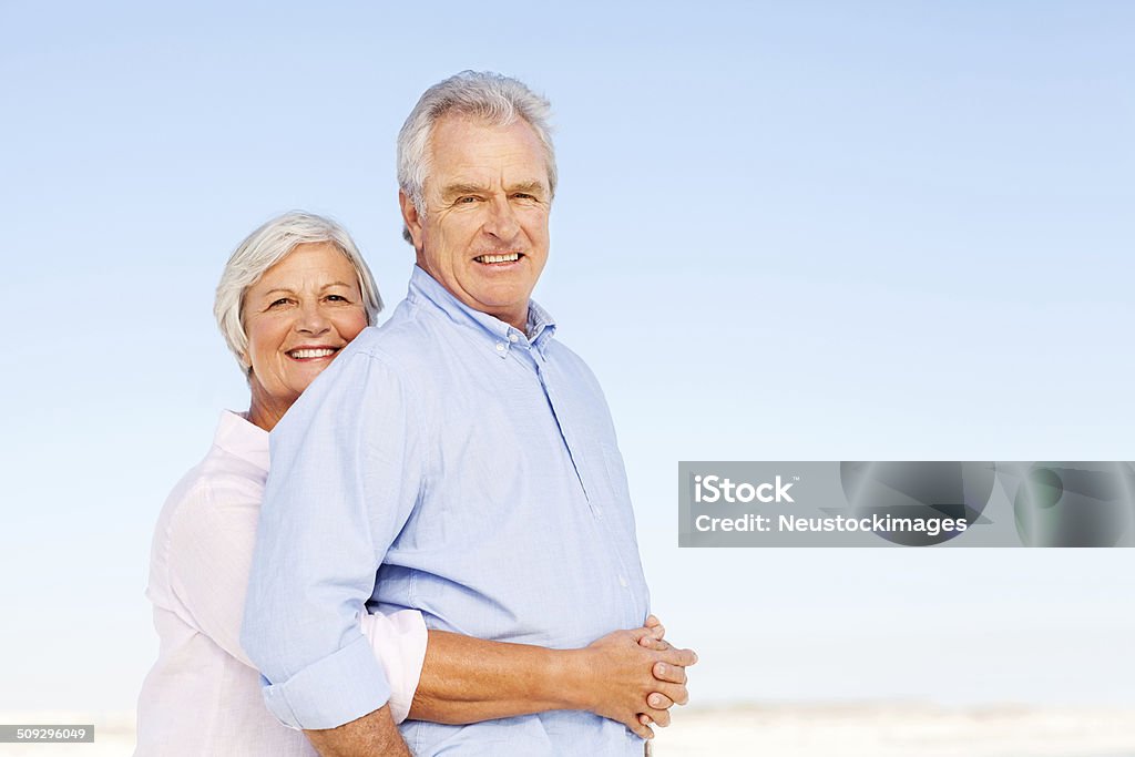 Liebevoll Senior Frau umarmen Mann von hinten auf Clear Blue - Lizenzfrei 60-64 Jahre Stock-Foto