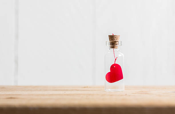 istock Love heart message in a bottle on wood table 509297596