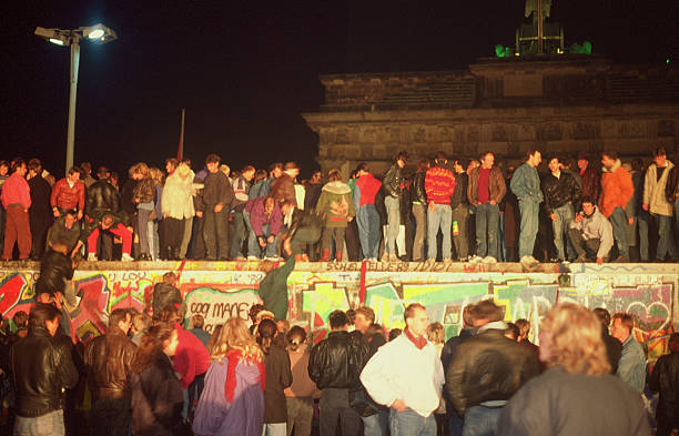Fall of the Berliner wall 1989 Berlin, Germany - November 9, 1989:"these is a scanned film" It is the night of the 9th of November 1989, just some hours later after that it has been anounced that people from east germany can travel into the west. People are standing on the wall which separates west- from east Berlin. The wall has fallen and people are celebrating it. These pictures is taken at the Brandenburger Tor, which by that time was located in east Berlin. In that night it was the first time after 28 years that people could cross the border without being killed. "these is scanned film" east germany photos stock pictures, royalty-free photos & images