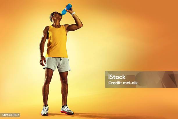 Foto de Esporte Jovem Atleta Beber Água De Garrafa Depois De Correr e mais fotos de stock de Homens