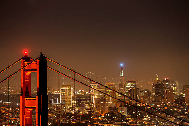 d'oro cancello ponte e san francisco skyline notturno - golden gate bridge close up steel cable suspension bridge foto e immagini stock