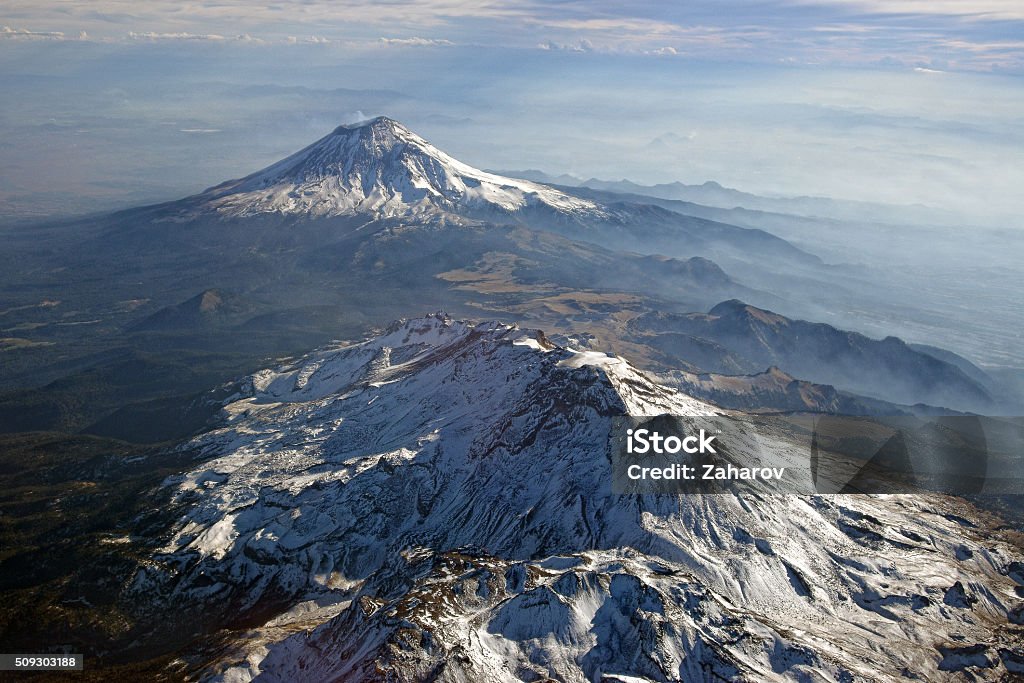 Volcanes Popocatepetl and Iztaccihuatl, Mexico. View from plain. In the background is the active volcano Popocatepetl, 5426 m, the second highest mountain of Mexico. In the foreground is the extinct volcano Iztaccihuatl. Popocatepetl Volcano Stock Photo