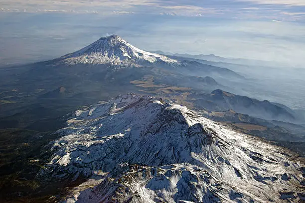 In the background is the active volcano Popocatepetl, 5426 m, the second highest mountain of Mexico. In the foreground is the extinct volcano Iztaccihuatl.