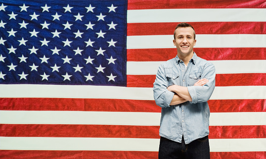 Smiling man in front of American flaghttp://www.twodozendesign.info/i/1.png