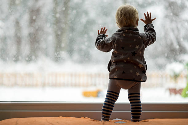 istock Toddler child standing in front of a big window 509307854