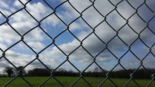 istock Chain-link fence, cloudy sky background 509312220