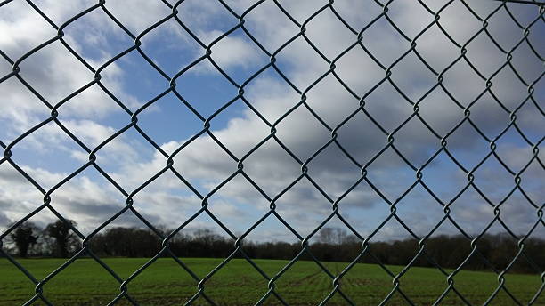 istock Chain-link fence - Sky, clouds, field. 509313204