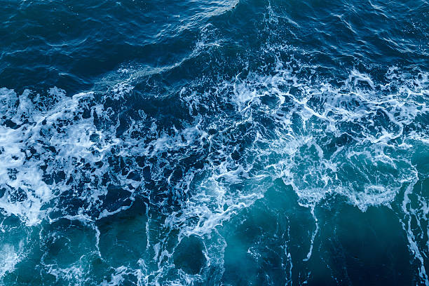Blue sea texture with waves and foam stock photo