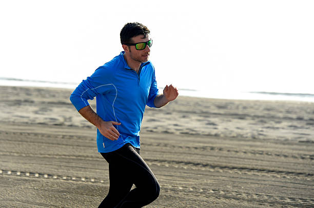 istock sport man running on desert beach in training workout 509315454