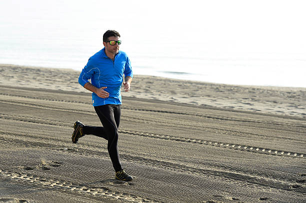 istock sport man running on desert beach in training workout 509315614