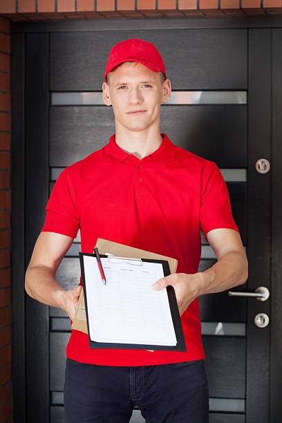 jeune homme avec le presse-papiers et de livraison formule - shipping supplies photos et images de collection