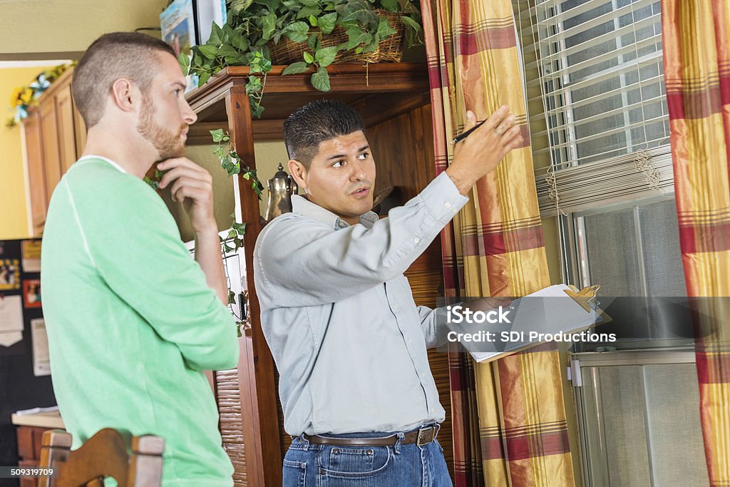 Home inspector explaining damage and repairs to homeowner Home Interior Stock Photo