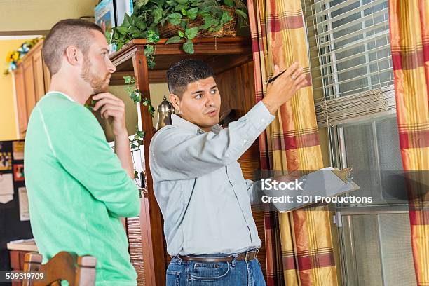 Home Inspector Explaining Damage And Repairs To Homeowner Stock Photo - Download Image Now