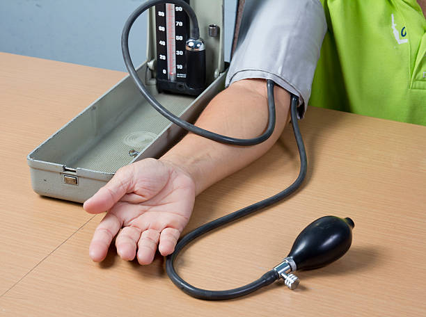 verificar a pressão de sangue de um paciente - patient blood pressure gauge doctor male - fotografias e filmes do acervo