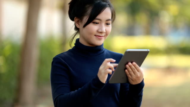 Woman use Tablet at Nature park