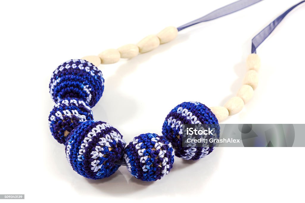 Crochet beads Blue beads of balls juniper tied with thread handmade hand motor development babies on white background Breastfeeding Stock Photo