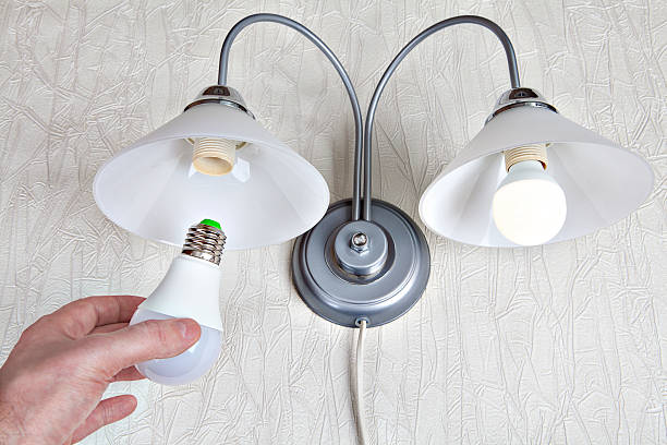 istock Replacing the bulbs in wall lights, hand holds  LED lamp. 509343290