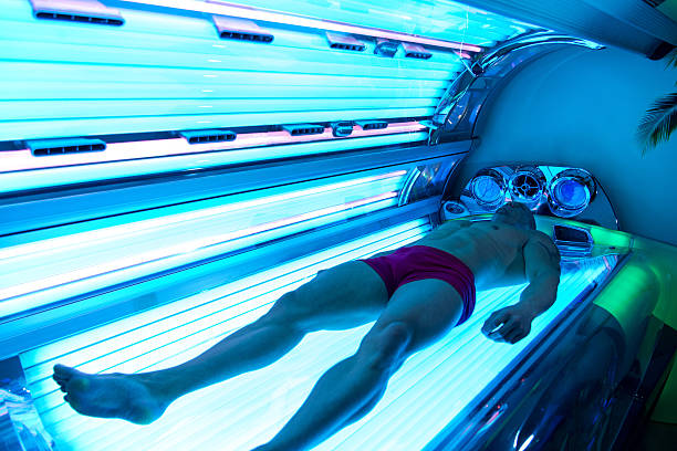 Young Muscular Man At Solarium In Beauty Salon Young Muscular Man At Solarium In Beauty Salon tanning bed stock pictures, royalty-free photos & images