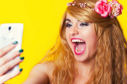 Hermosa mujer joven haciendo selfie con smartphone en amarillo photo