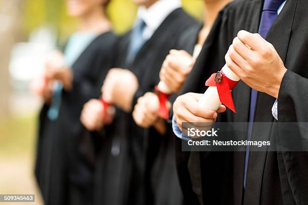 Closeup Graduate Students Holding Diplomas At College Stock Photo - Download Image Now