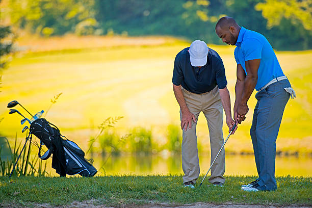 Golf Pro Teaching Male Golfer Golf pro teaching beginner golfer on driving range. Coaching, Mentorship for Golf Club stock pictures, royalty-free photos & images