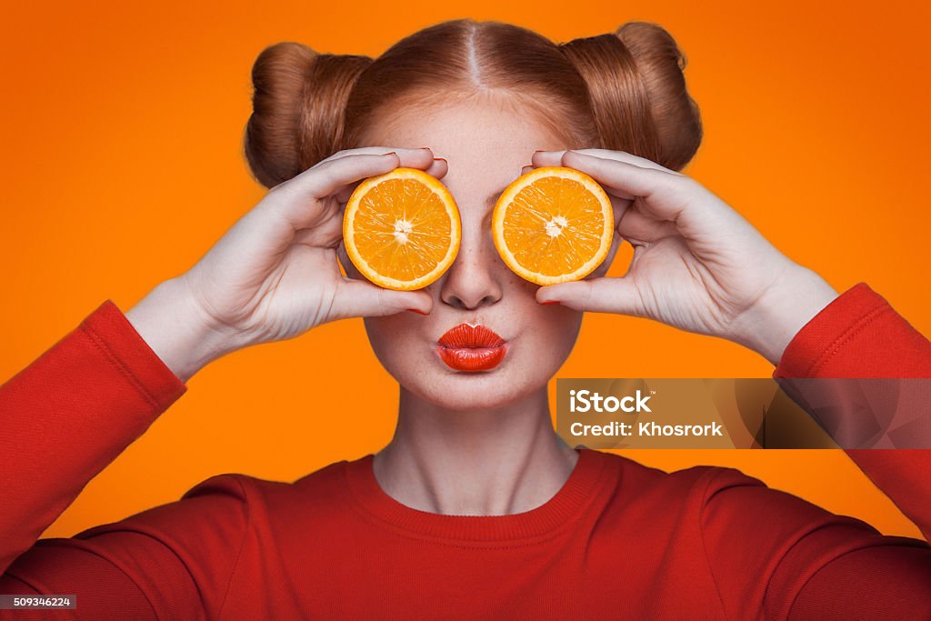 Modelo de moda joven Guapo con naranja. Foto de estudio. - Foto de stock de Diversión libre de derechos