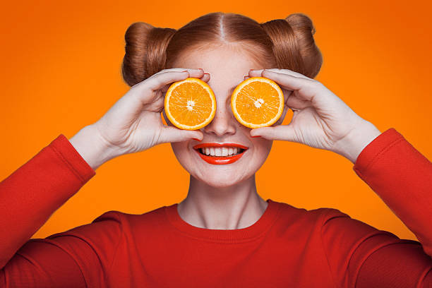 modelo de moda jovem bonito com laranja. foto de estúdio. - orange tone - fotografias e filmes do acervo