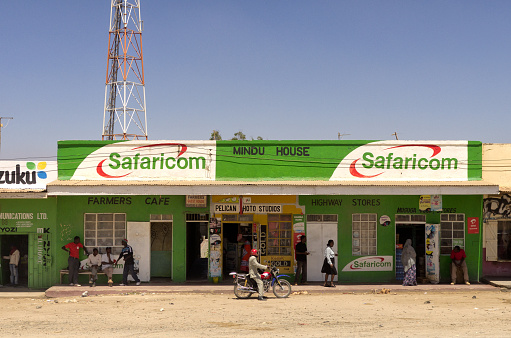 Nairobi, Kenya - Feb 6, 2012: Brightly colored buildings with advertising for cellular phone companies in rural Kenya. Safaricom, Ltd is a leading mobile network operator in Kenya. It was formed in 1997 as a fully owned subsidiary of Telkom Kenya. In May 2000, Vodafone group Plc of the United Kingdom, the world's largest telecommunication company, acquired a 40% stake and management responsibility for the company.