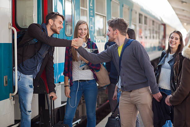 Young people saying goodby on a train station People on train station. Most of them students, going home for weekend. Saying goodby by handshake. Happy. blond hair fine art portrait portrait women stock pictures, royalty-free photos & images