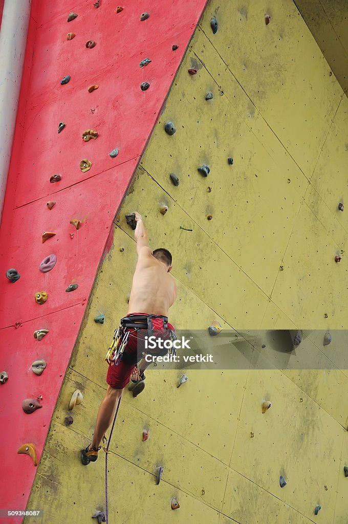 Muscular man climbing Muscular man climbing on a big wall Activity Stock Photo