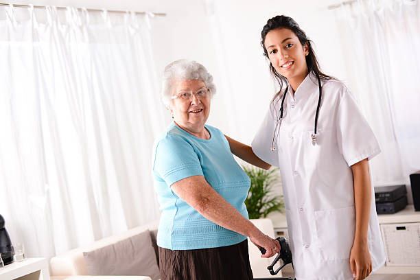 istock cheerful young rehab nurse helping elderly woman using walker 509349727