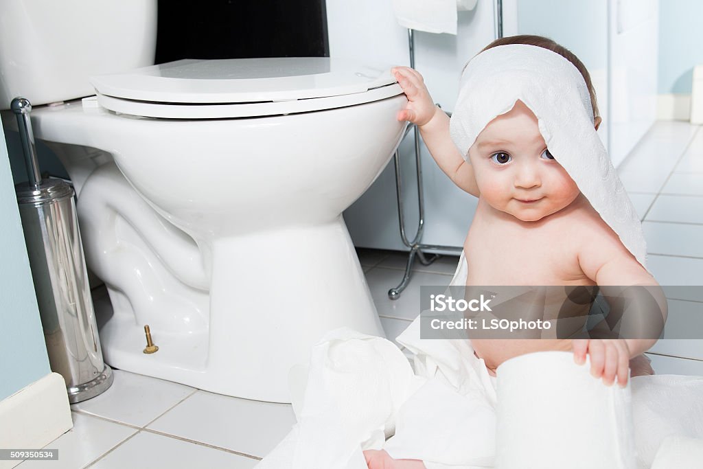 Niño ripping de papel higiénico en el baño - Foto de stock de Travesura libre de derechos