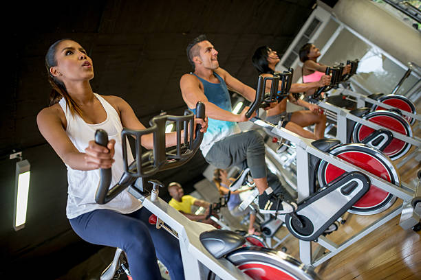 pessoas s'exercitando na academia de ginástica - spinning instructor exercising gym - fotografias e filmes do acervo