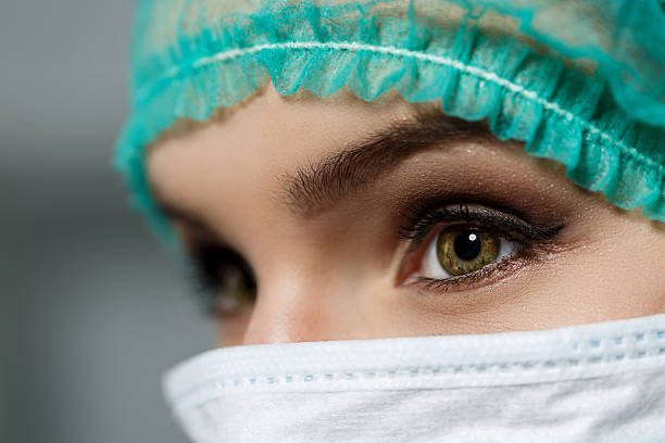femmina dottore indossando maschera protettiva per il viso e verde chirurgo tappo - nurse paramedic healthcare and medicine hygiene foto e immagini stock