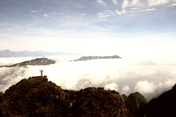 istock cheering young woman hiker open arms on mountain peak 509355718