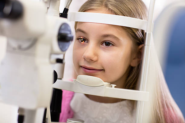 Girl look at ophthalmoscope stock photo