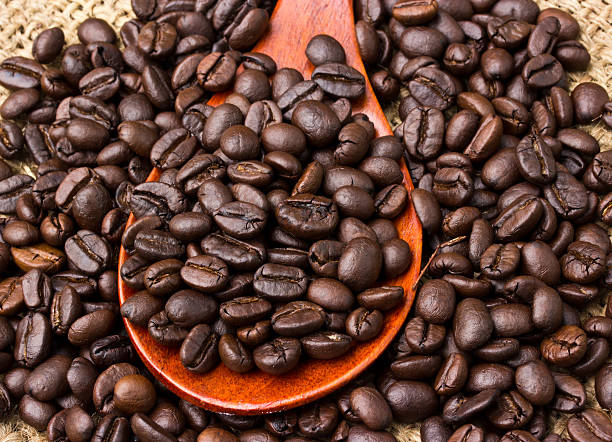 istock Coffee beans and wood spoon on vintage linen background 509362397