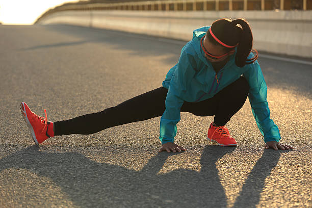 istock Young female runner stretching her legs on sunrise road 509364886