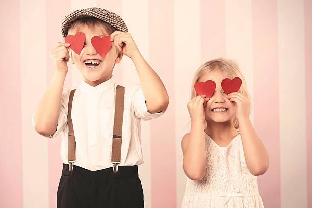 deux enfants avec des cœurs sur les yeux - valentines day romance boyfriend vertical photos et images de collection