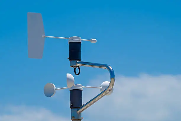 Anemometer of weatherstation, blue sky with clouds as background