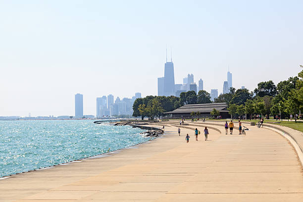 Chicago beachfront View of the beachfront, Lake Michigan and the silhouette of buildings in Downtown Chicago lake shore drive chicago stock pictures, royalty-free photos & images