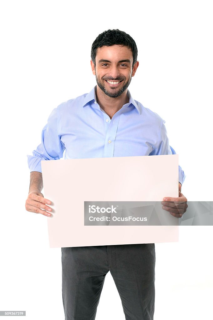 happy attractive businessman holding blank billboard as copyspace happy young handsome business man wearing beard, blue shirt and suit trousers in a spanish or latin ethnicityu look holding blank billboard for adding corporate text or marketting campaign using empty card as copy space isolated on white blackground Holding Stock Photo
