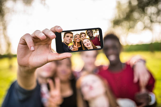 group of college student riendo y haciendo un autorretrato - mobile phone group of people photographing teenager fotografías e imágenes de stock