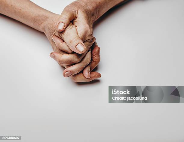 Senior Womans Hands On Grey Background Stock Photo - Download Image Now - Anxiety, Praying, Senior Adult