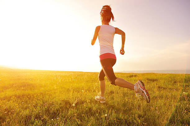 istock Runner athlete running on sunrise/sunset grass field 509391785