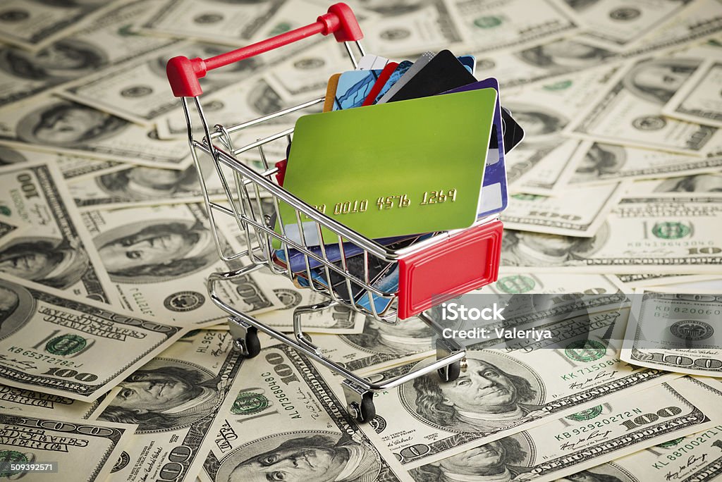 Credit card within shopping cart Credit card within shopping cart. Dollar background Bank - Financial Building Stock Photo